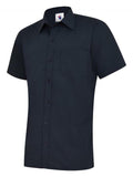 A navy, short-sleeved UC710 dress shirt with a button-up front and a single chest pocket, displayed on a plain background by Uneek.