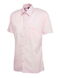 A pink, short-sleeved UC710 dress shirt with a button-up front and a single chest pocket, displayed on a plain background by Uneek.