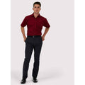 A man wearing a UC710 Maroon Uneek poplin Short sleeved shirt with Black trousers