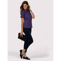 A woman wearing a UC712 Purple Uneek ladies poplin Short sleeved shirt with Navy trousers