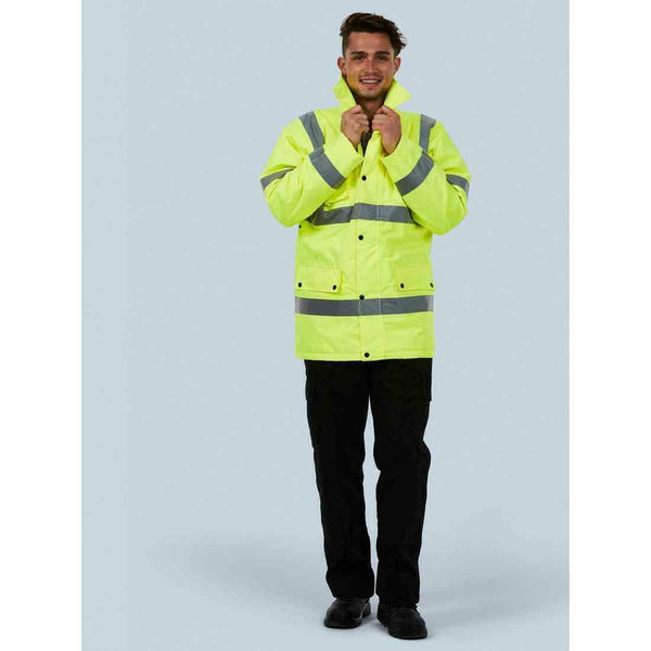 A man wearing a UC803 Yellow Uneek hi-viz road safety jacket with Black trousers