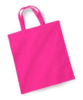 A vibrant pink tote bag, model W101S by Westford Mill, is shown lying flat against a white background. It features two handles and is crafted from sturdy and smooth fabric, making it ideal for carrying items.
