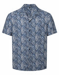 Introducing the Wombat WB500, a short-sleeved button-up shirt showcasing a tropical leaf pattern. This stylish design features overlapping leaves in varying shades of blue and white set against a navy background.