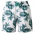 Wombat WB900 swim trunks featuring a white base with a green tropical leaf pattern and a teal drawstring.