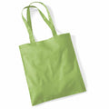 A Westford Mill WM101 tote bag, featuring a simple green design and two handles, lies flat against a white background.