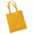 A Westford Mill WM101 tote bag in plain yellow, equipped with long handles, lies flat against a white background. The fabric looks smooth and robust, perfect for carrying items.