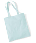 Placed on a flat white surface is the WM101 by Westford Mill, a light blue reusable tote bag featuring two long handles and a simple, logo-free design.