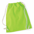 A Westford Mill WM110 drawstring backpack in vibrant green, featuring two white cords, lies flat. The fabric has a smooth texture, and the design remains simple and unembellished.