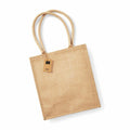 The Westford Mill WM409 is a beige jute tote bag featuring two handles and a small attached tag.