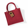 A red jute tote bag with two handles and a brown tag attached, featured against a white background, branded as Westford Mill's WM412.