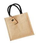 A rectangular jute bag branded as Westford Mill's WM413, featuring black handles and a small tag with partially obscured text, is displayed against a plain white background.