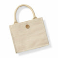 The square beige woven tote bag, crafted by Westford Mill, features two short rope handles and a wooden button closure at the top center. Its design is simple and minimalist, akin to the elegance of a Juco Mini Gift Bag.