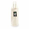 The WM620 by Westford Mill is a beige canvas wine tote bag equipped with two handles. It features a black tag displaying the Fair Trade logo and text indicating that it is made from 100% organic cotton. The bag is positioned upright against a white background.