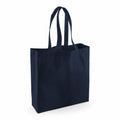 A plain tote bag in dark blue, featuring two long handles and standing upright against a white background, branded as Westford Mill's WM623 model.
