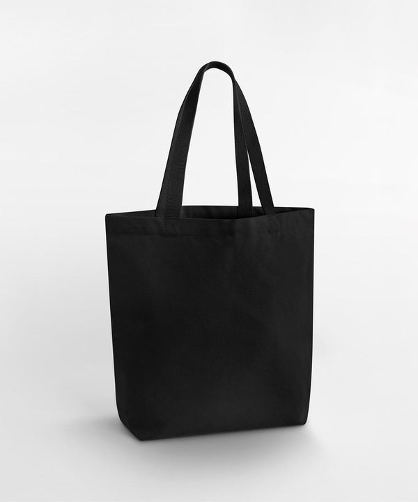 A Westford Mill Heavyweight canvas tote bag in plain black stands upright on a white background, featuring two handles and a simple, unadorned design with no visible logos or patterns.