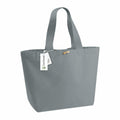A grey tote bag featuring two handles and a small wooden toggle closure. An attached tag on the handle showcases the Westford Mill brand, along with a recycling symbol. This WM855 model embodies a simple, eco-friendly design.