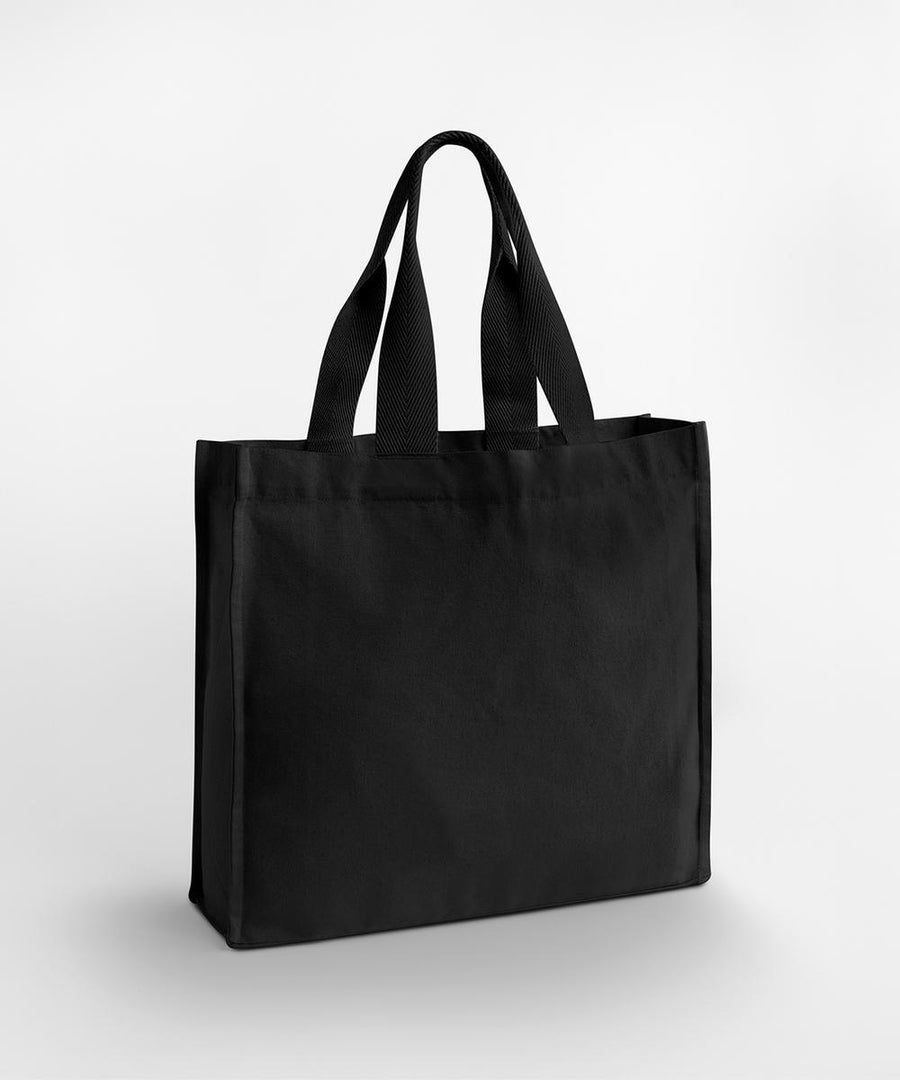 The Westford Mill Chevron Handle Shopper stands upright on a white background, featuring two sturdy chevron-patterned handles and a plain black canvas-like fabric.
