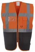 The Yoko YK002 is an orange safety vest with gray reflective stripes, featuring a clear ID holder. It includes a small orange pocket with a flap on the chest and two large black pockets at the front bottom. The vest has a front zipper closure for convenience.