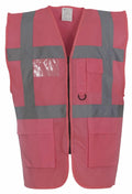 A vibrant pink Yoko YK002 safety vest featuring wide gray reflective stripes, a central zipper, and multiple pockets.