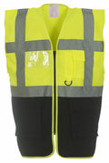 The Yoko YK002 high-visibility safety vest in fluorescent yellow features reflective gray stripes, a clear chest pocket, and multiple black pockets at the bottom. The vest is showcased on a white background.