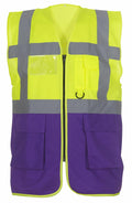 The Yoko YK002 is a high-visibility safety vest in bright yellow and purple with reflective gray stripes, and it features pockets along with a zipper front.