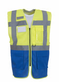 The Yoko YK015 is a high-visibility safety vest featuring a blue bottom half and a yellow top half. It includes gray reflective stripes, several pockets, and a secure front closure.