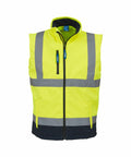 The Yoko YK050 high-visibility safety vest comes in bright yellow and features reflective silver stripes across the chest and waist. It includes a front zipper, a dark blue lower panel, and a raised collar for added coverage.