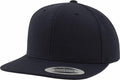 A plain black snapback hat with a flat brim features a sticker on the brim that reads "The Classic Snapback Yupoong Since 1974." This is the YP001 by Flexfit By Yupoong.