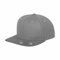 The YP001 snapback cap from Flexfit By Yupoong features a plain gray design with a flat brim. It is constructed with six panels, visible stitching, and has a small round button on top, along with a sticker on the brim.