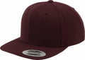 A deep maroon YP001 snapback hat by Flexfit By Yupoong, featuring a flat brim and timeless design. A sticker on the brim reads The Classic Snapback Yupoong Since 1974. The cap is angled slightly to emphasize its shape and construction.