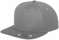 The Flexfit By Yupoong YP001 is a gray snapback cap with a flat brim and round crown, highlighted by a sticker on the brim. It features visible stitching details around the panels and top button, displayed at an angle to show its side and front profile.