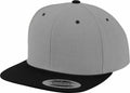 The YP002 by Flexfit By Yupoong is a gray snapback cap featuring a black brim and a round sticker on the visor.