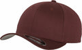 A maroon Flexfit By Yupoong baseball cap, product number YP004, featuring a slightly curved brim, is displayed from a side angle. The cap includes a sticker on the interior of the brim and has small ventilation holes on top.