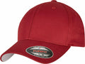 A red baseball cap with a curved brim featuring a sticker displaying the Flexfit By Yupoong logo and text, identified as product YP004.
