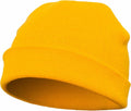 A vibrant yellow knit beanie with a folded brim is positioned at an angle, showcasing its simple and casual design with a soft texture and bright color. This hat is the YP013 from Flexfit By Yupoong.