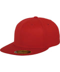 The YP017 by Flexfit By Yupoong is a solid red baseball cap featuring a flat brim and a circular sticker on the underside.