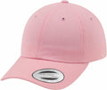 A pink baseball cap with a curved brim features a small oval sticker on the front, displaying "Yupoong" and "The Classics" in black text. This product is known as YP022 from the brand Flexfit By Yupoong.