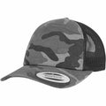 Flexfit By Yupoong's YP029, a snapback cap featuring a camouflage pattern, includes a black mesh back and comes with a round sticker on the brim.