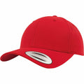 A YP035 baseball cap from Flexfit By Yupoong, featuring a bright red color with a curved brim and a sticker on the front, indicating its classic style.