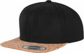 A black Flexfit By Yupoong YP082 snapback hat featuring a cork brim and a circular brand sticker on the front.