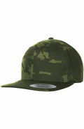 Discover the YP083 by Flexfit By Yupoong, a green camouflage snapback cap with a flat brim and a signature sticker on the brim.