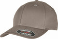 A taupe baseball cap with a curved brim and stitched panels, featuring a Flexfit By Yupoong sticker that indicates its brand and size information. The YP113 cap is showcased against a plain white background.