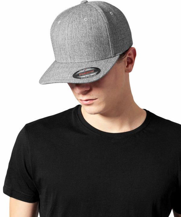 A person wearing a black t-shirt and a gray Flexfit By Yupoong YP117 with the brim facing forward, looking down.