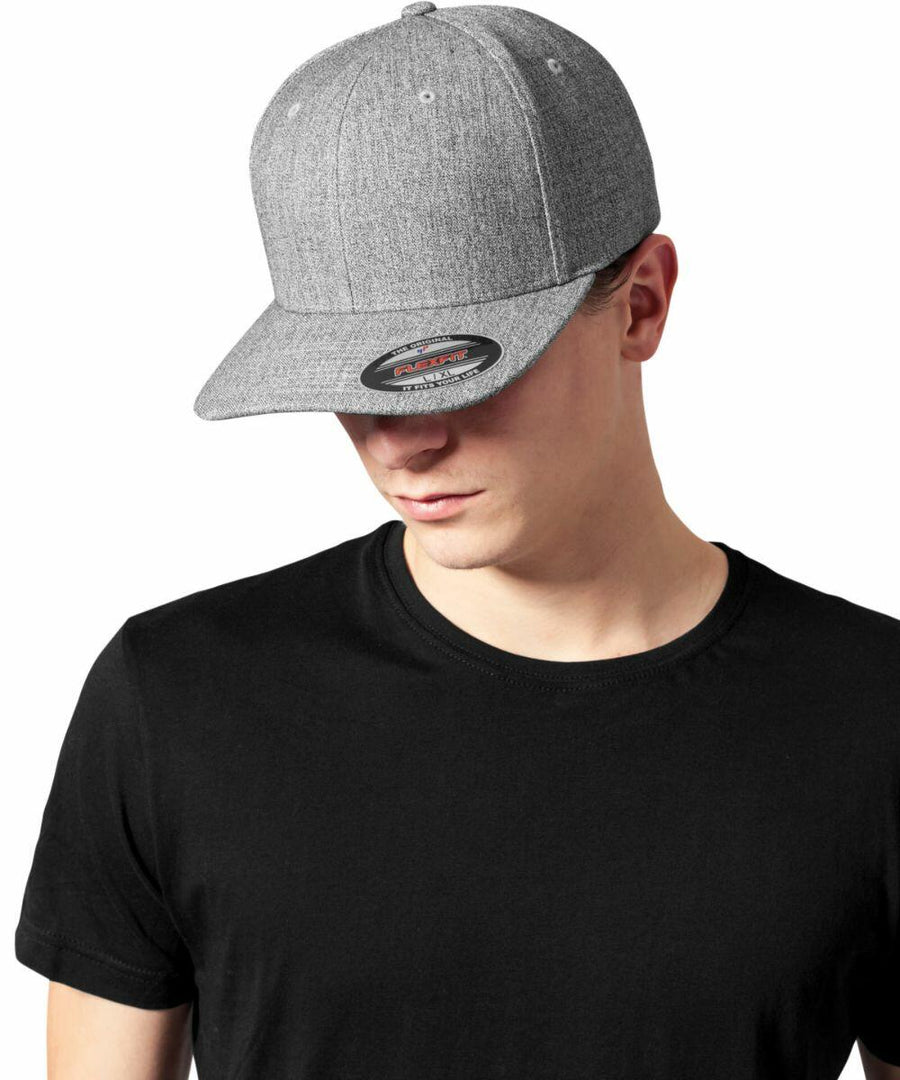 A person wearing a black t-shirt and a gray Flexfit By Yupoong YP117 with the brim facing forward, looking down.