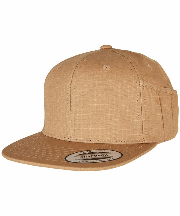 A tan Flexfit By Yupoong snapback hat called the YP171 with a flat brim and an adjustable strap at the back. The hat features a small seam pattern and a sticker on the brim.