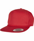 A red snapback hat with a flat brim and a woven rope detail above the brim. The hat features a sticker on the brim that reads "YP207 by Flexfit By Yupoong, since 1974.