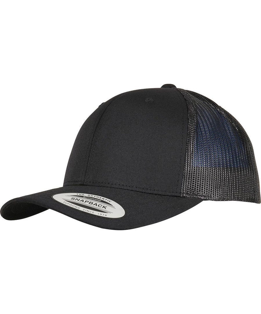 The Flexfit by Yupoong Trucker recycled polyester fabric cap (6606TR) features a black design, curved brim, mesh back panels, and a snapback sticker. It’s angled against a white background.