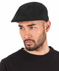 A man with a beard wearing a black Flexfit By Yupoong YP248 cap and black shirt, looking slightly to the side.