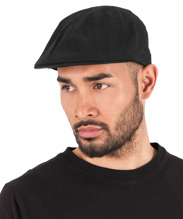 A man with a beard wearing a black Flexfit By Yupoong YP248 cap and black shirt, looking slightly to the side.