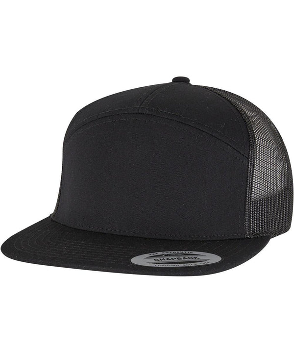 The Flexfit by Yupoong 7-panel classic trucker cap (9294) features a black flat peak, solid black front, mesh back panels, an adjustable snapback fastening, and a sticker on the peak.